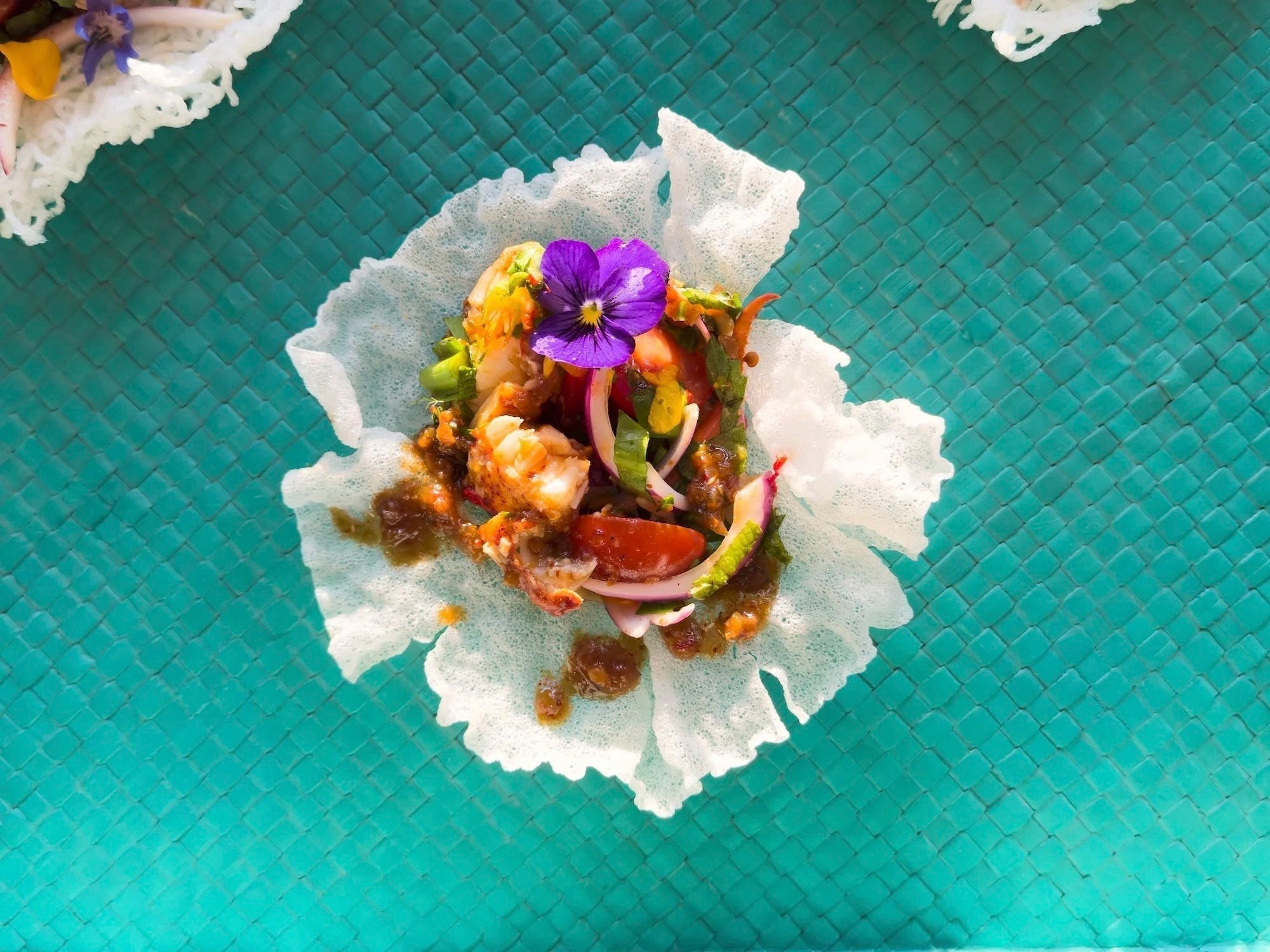 Thai-inspired lobster salad with spicy chili sauce, fresh herbs, and colorful vegetables served in a summer-style bowl – fusion seafood dish from Maine with Thai flavors.