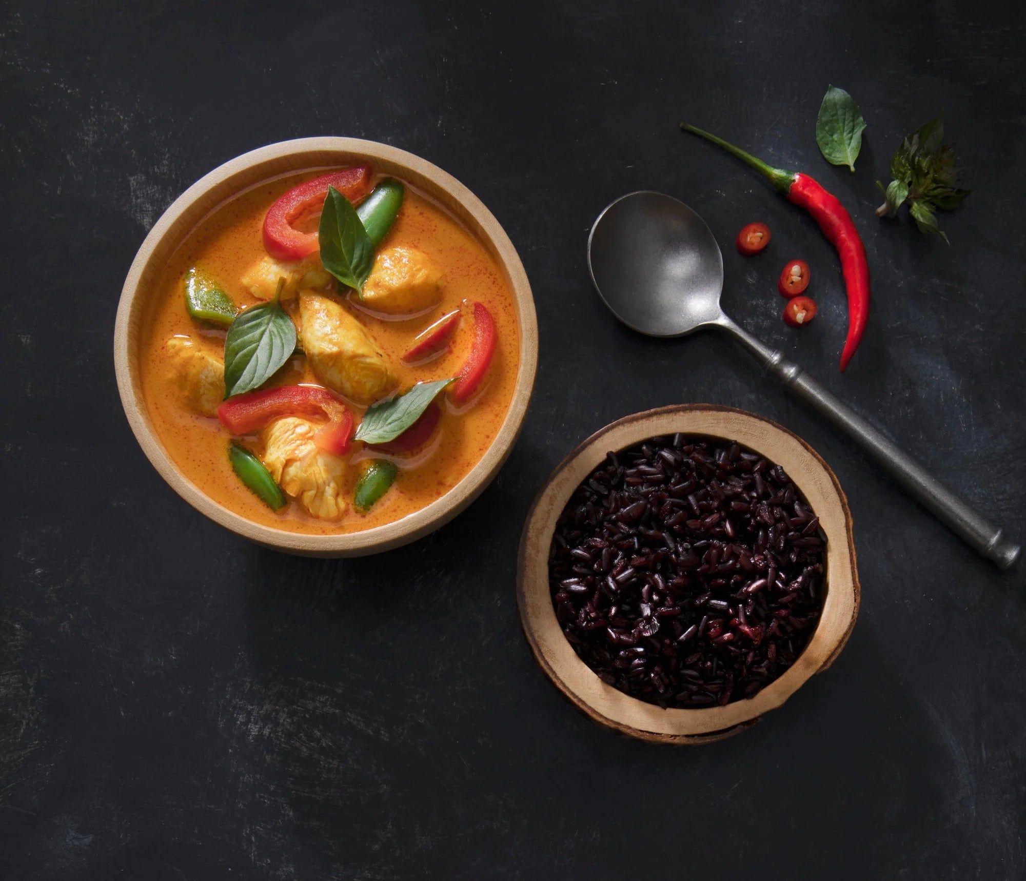 Bowl of classic Thai red curry with tender chicken, bell peppers, and Thai basil on jasmine rice
