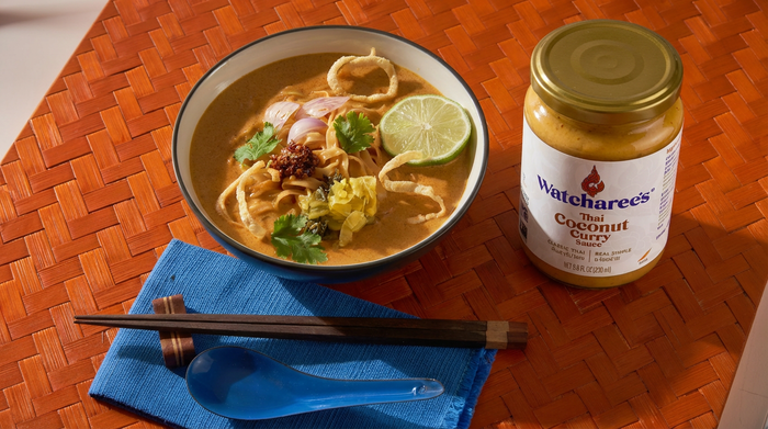 Khao Soi served in Chiang Mai style. Egg noodles in coconut curry broth topped with crispy noodles, pickled mustard greens, shallots, lime, and chili oil.